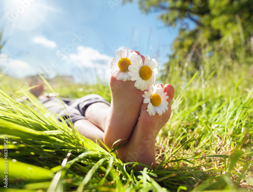 Fototapeta Naklejka Na Ścianę i Meble -  Child lying in meadow relaxing in summer sunshine