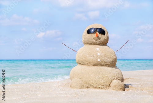 Smiling sandy happy man in sunglasses on the sea beach