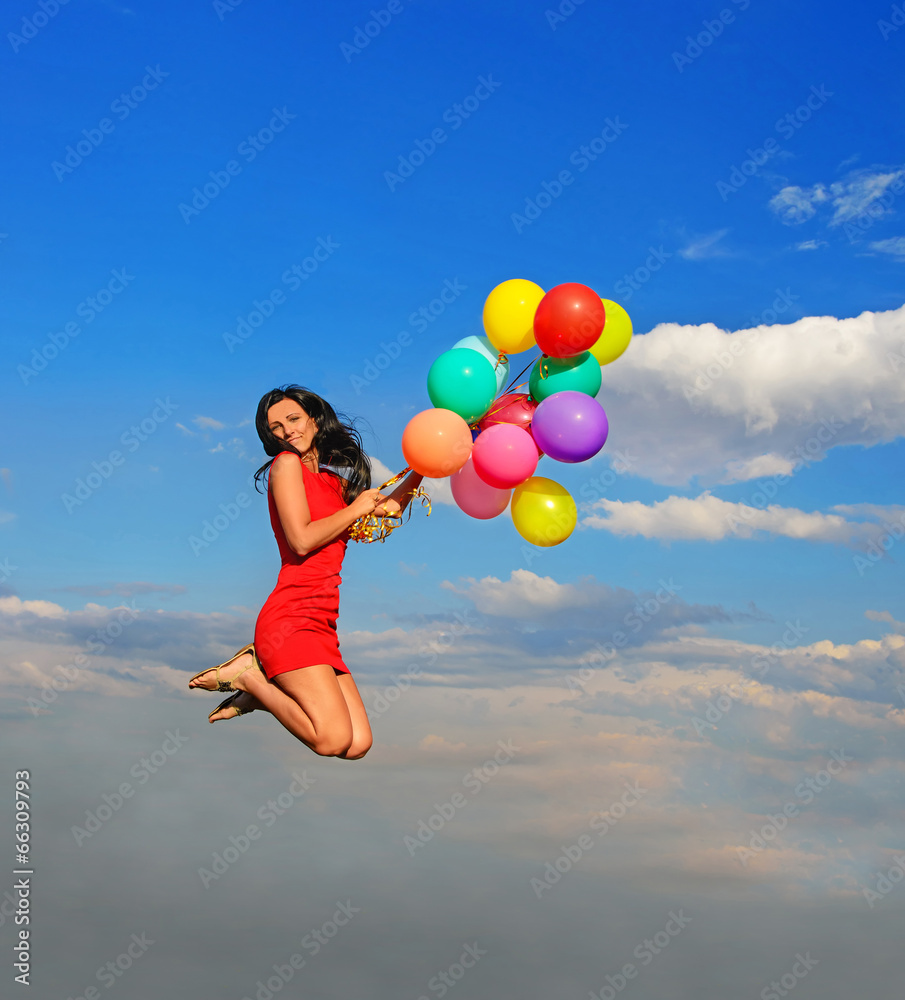 Young pretty girl jump on colorful balloons against blue sky Young pretty girl jump on colorful balloons against blue sky