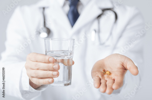 doctor hands giving capsule and glass of water