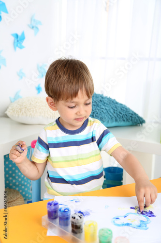 Cute little boy painting in...