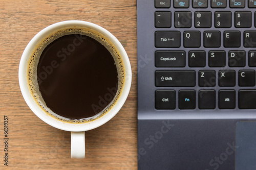 Top view of coffee cup , laptop on wooden table