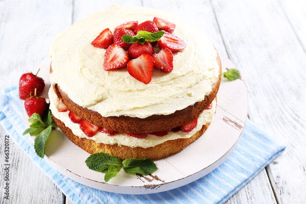 Delicious biscuit cake with strawberries on table close-up