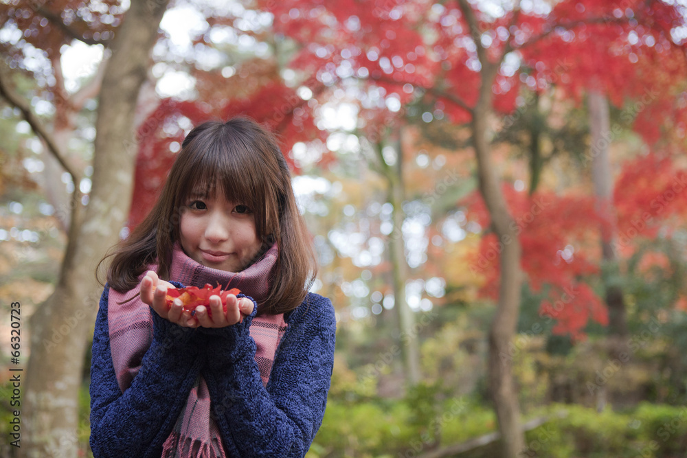 秋の紅葉の公園で落ち葉を手のひらに乗せる笑顔の女性 Stock 写真 Adobe Stock
