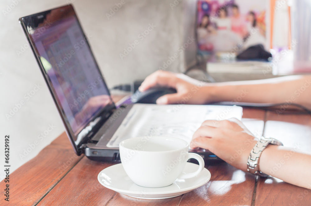 Woman using laptop with a cup of coffee Woman using laptop with a cup of coffee