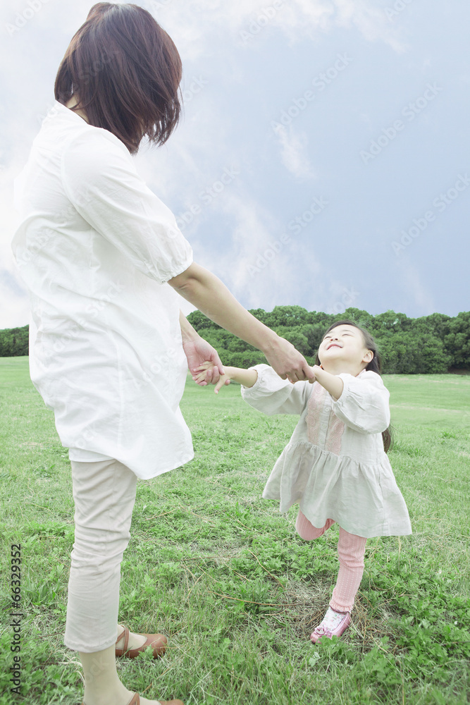 芝生で遊ぶ母と子