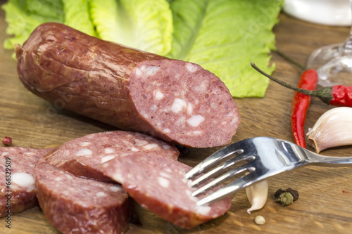Bild auf Leinwand sausages on a wooden plate with vegetables in a restaurant