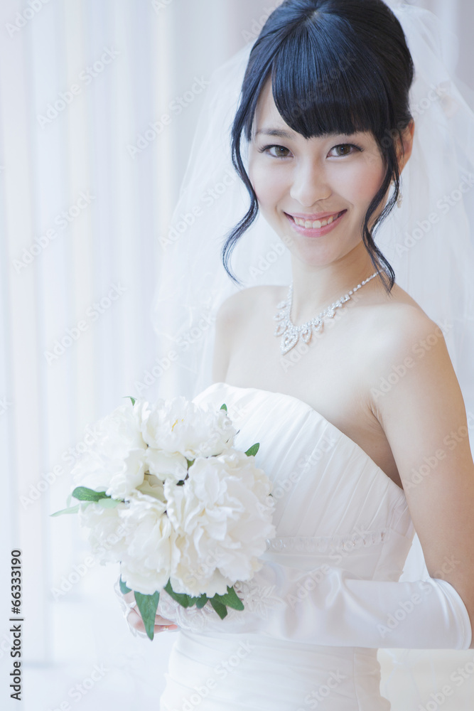 Naklejka premium ブーケを持ったウエディングドレス姿の女性