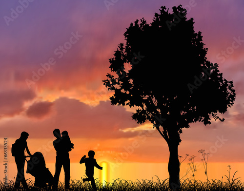family and tree silhouettes at sunset
