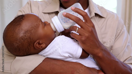 Happy father feeding cute baby son
