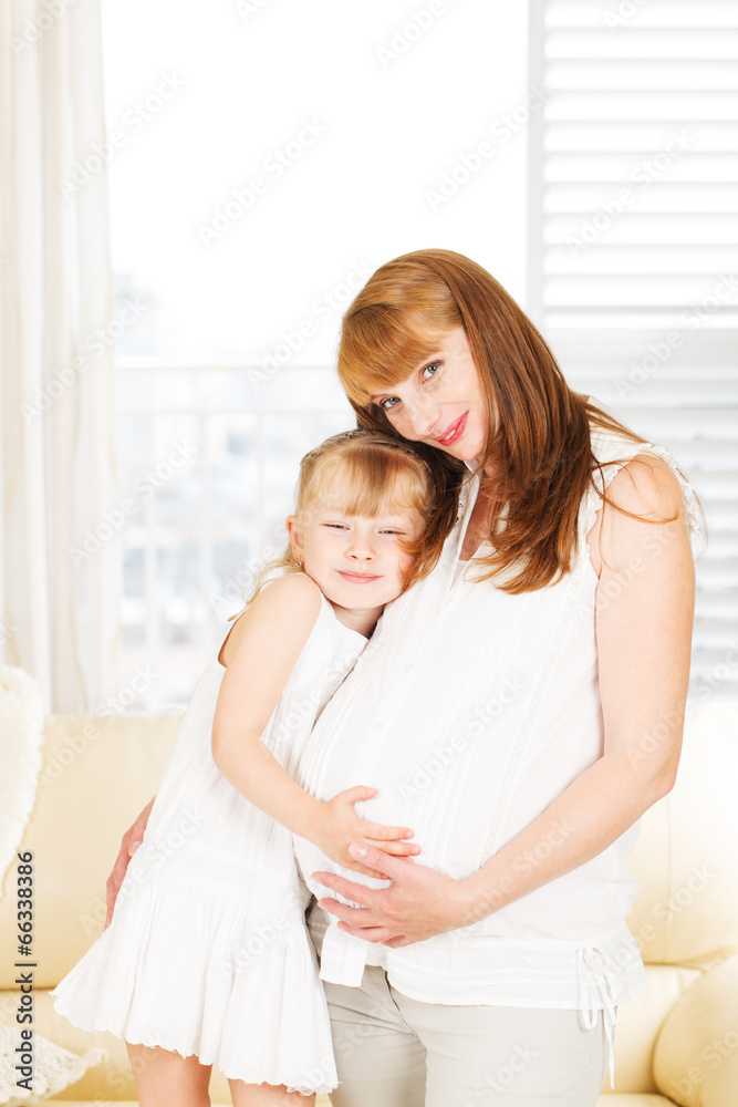 Little girl embracing her pregnant mother
