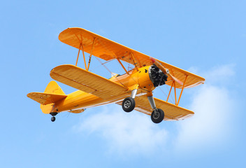 Acrylglasbilder Alte Flugzeuge Gelber Doppeldecker am blauen Himmel  © Kletr