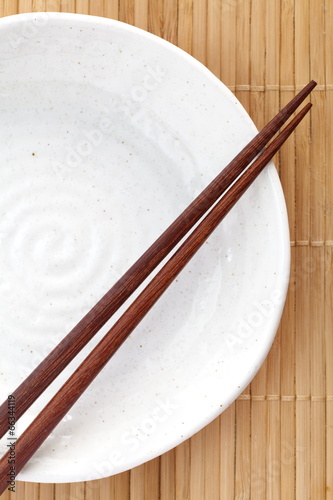 asian design white empty plate on bamboo mat