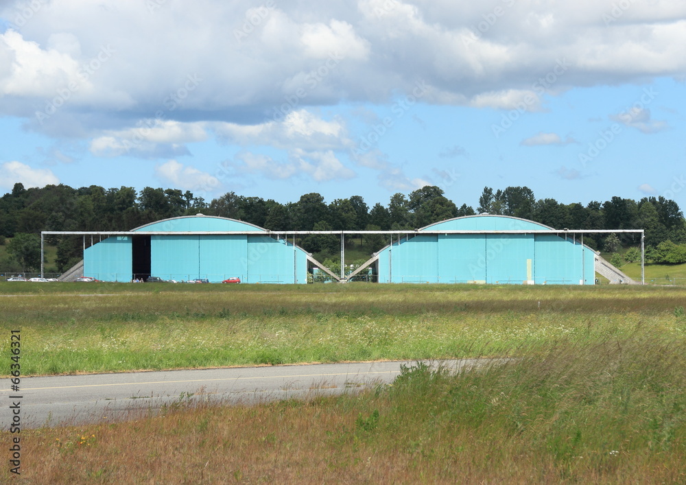 Airplane hangar isolated at airfield with clouds Airplane hangar isolated at airfield with clouds