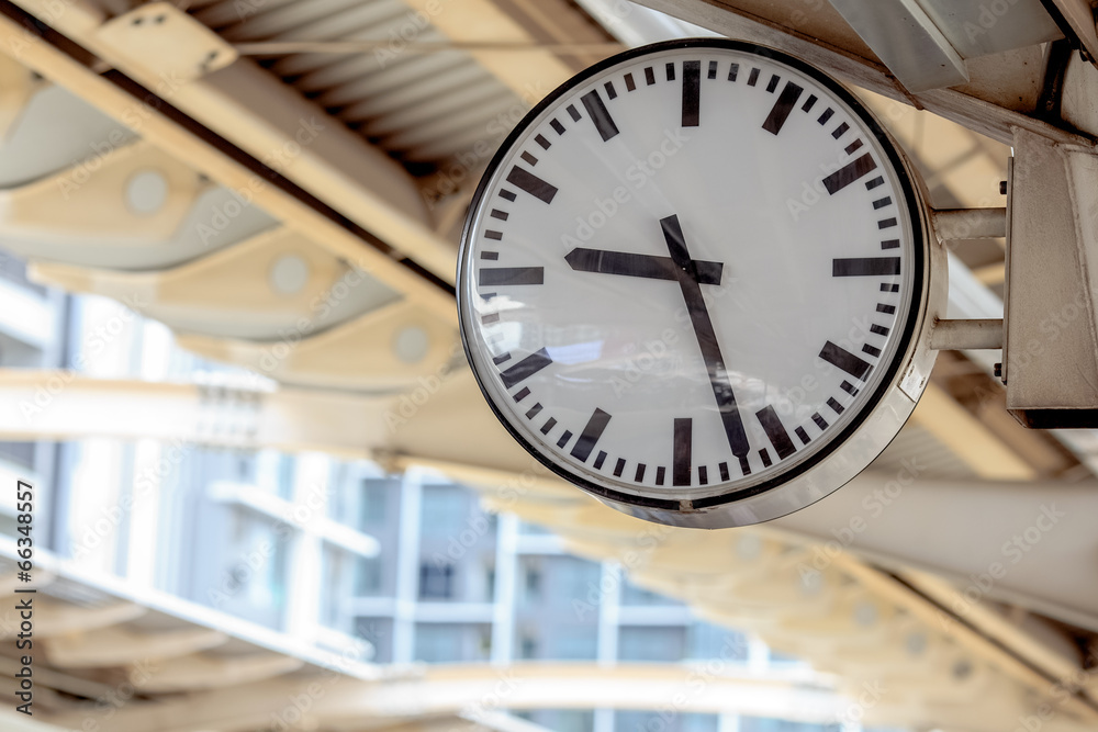 Obraz premium Public clock In a railway station with roof perspective
