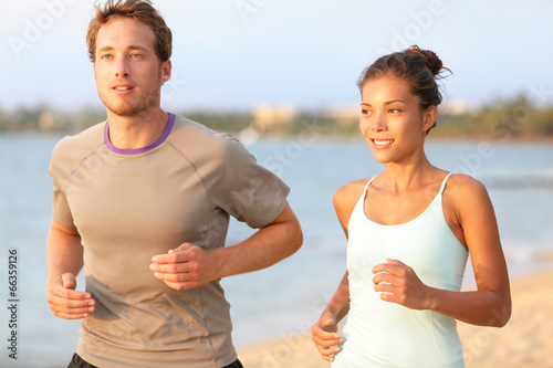 Running jogging couple training on summer beach