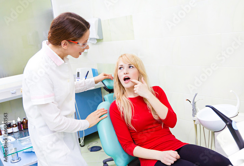 Woman patient in dentist office getting consultation from doctor
