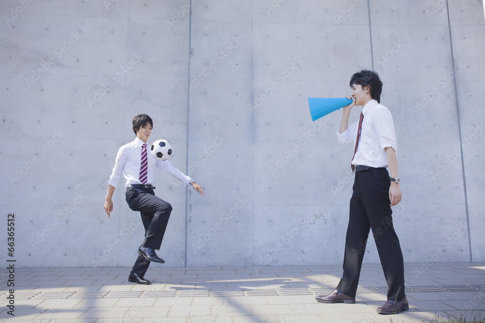 Fototapeta premium リフティングをするビジネスマンと監督をするビジネスマン