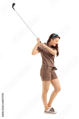 Young woman swinging a golf club