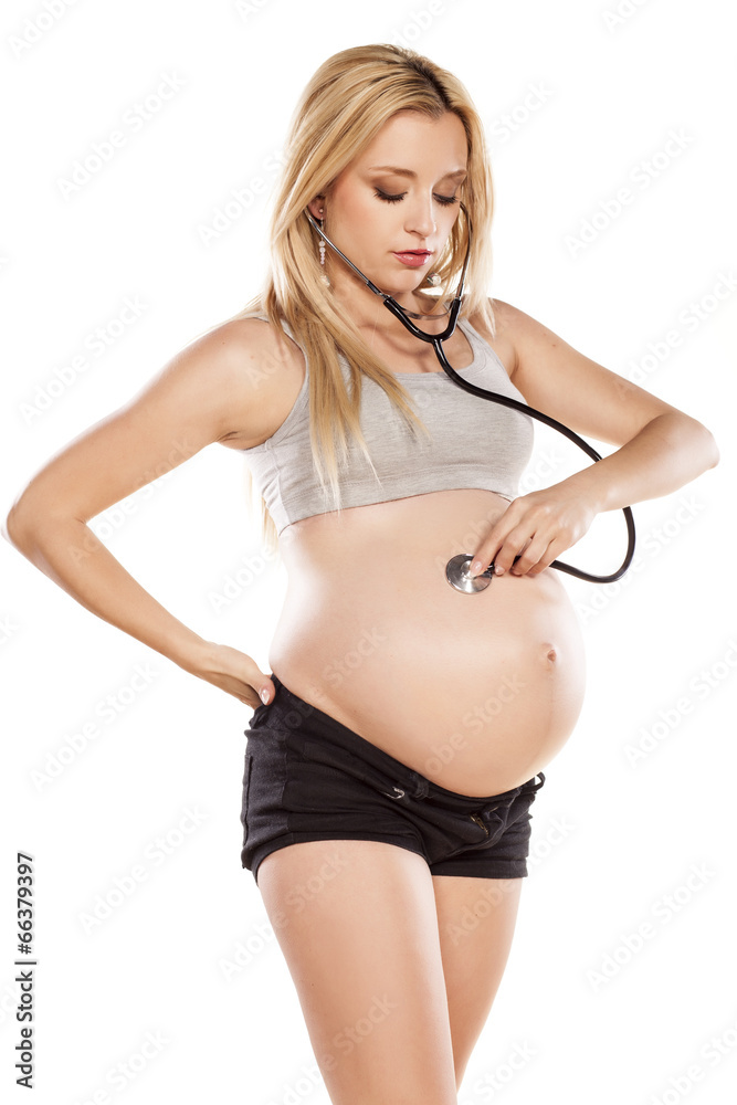 Fototapeta premium pregnant woman using a stethoscope listening to her belly