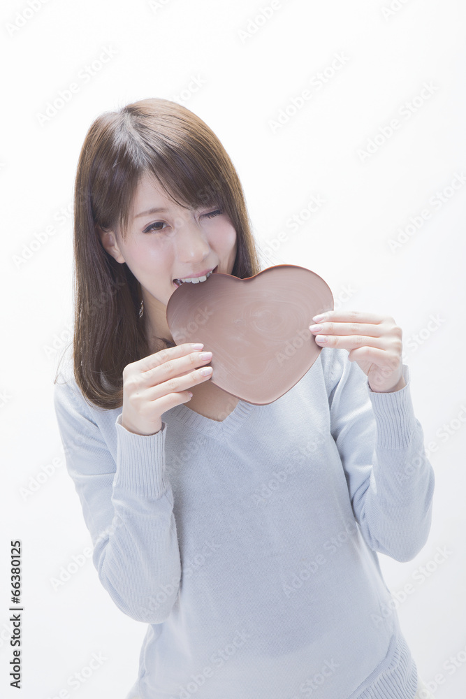 ハート形のチョコレートを食べる女性