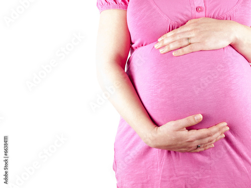 Pregnant young woman in pink holding her belly