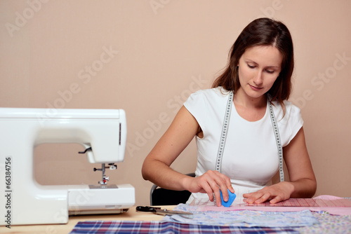 Young attractive woman mark out fabric