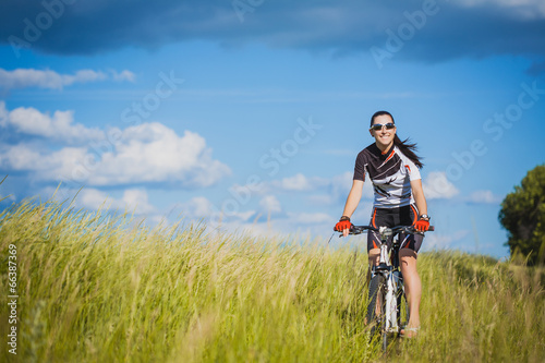 Young Woman is riding bicycle outside. Healthy Lifestyle