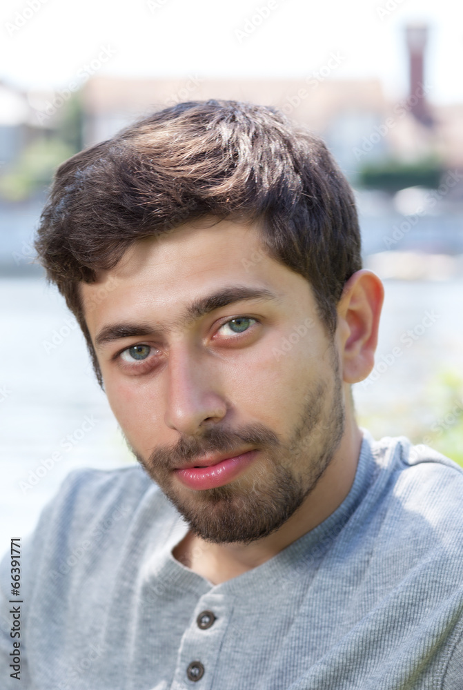 Portrait of a smiling man with beard in a grey shirt outside Portrait of a smiling man with beard in a grey shirt outside