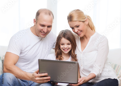 parents and little girl with laptop at home