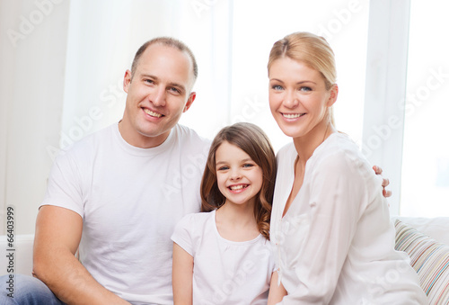 smiling parents and little girl at home