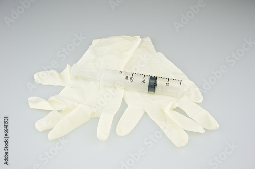 Big plastic syringe place on latex gloves © eaglesky