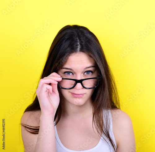 Portrait of strict young woman against yellow background