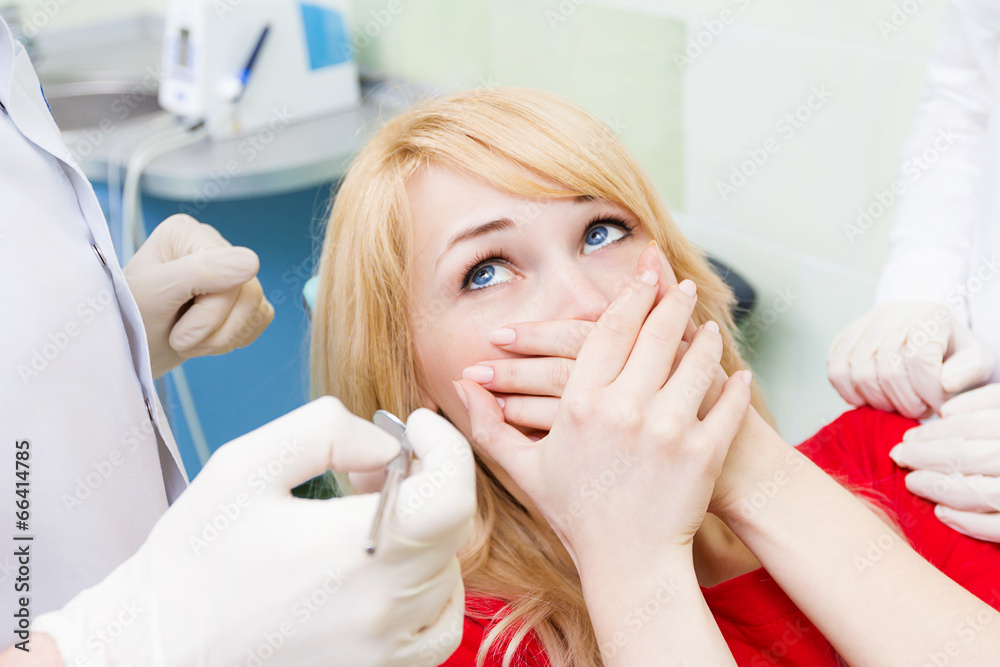 Fototapeta premium Female patient in dentist office afraid of doctor, dentist