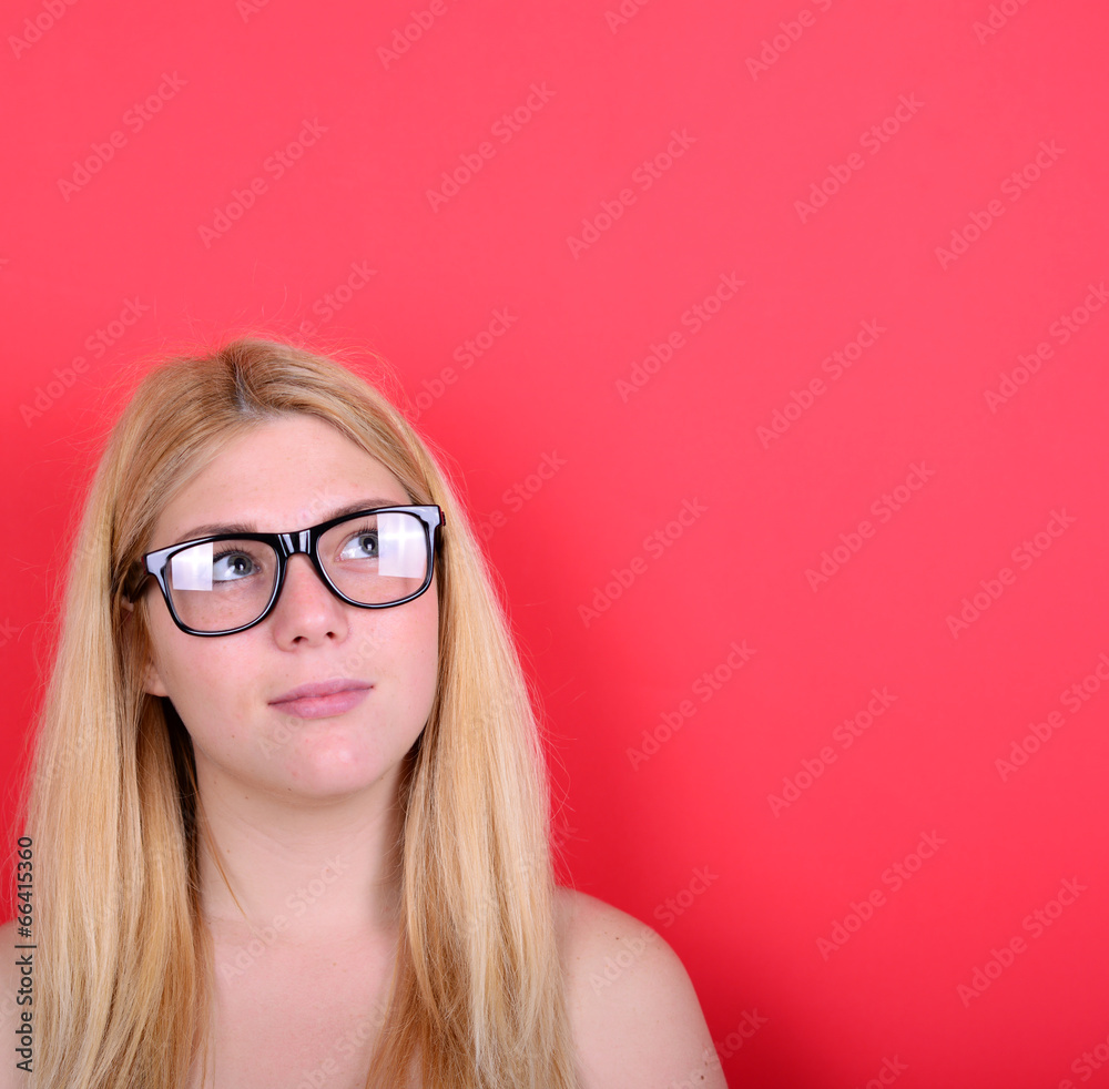 Portrait of beautiful girl looking up against red background