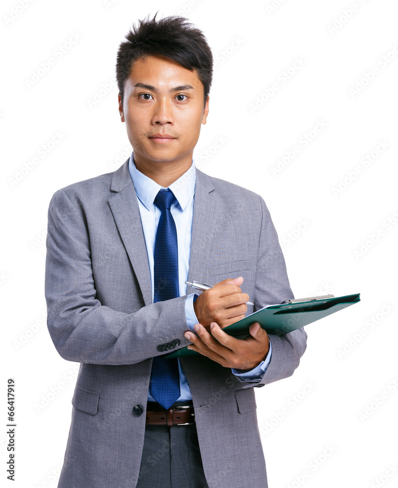 Serious businessman write on clipboard Serious businessman write on clipboard