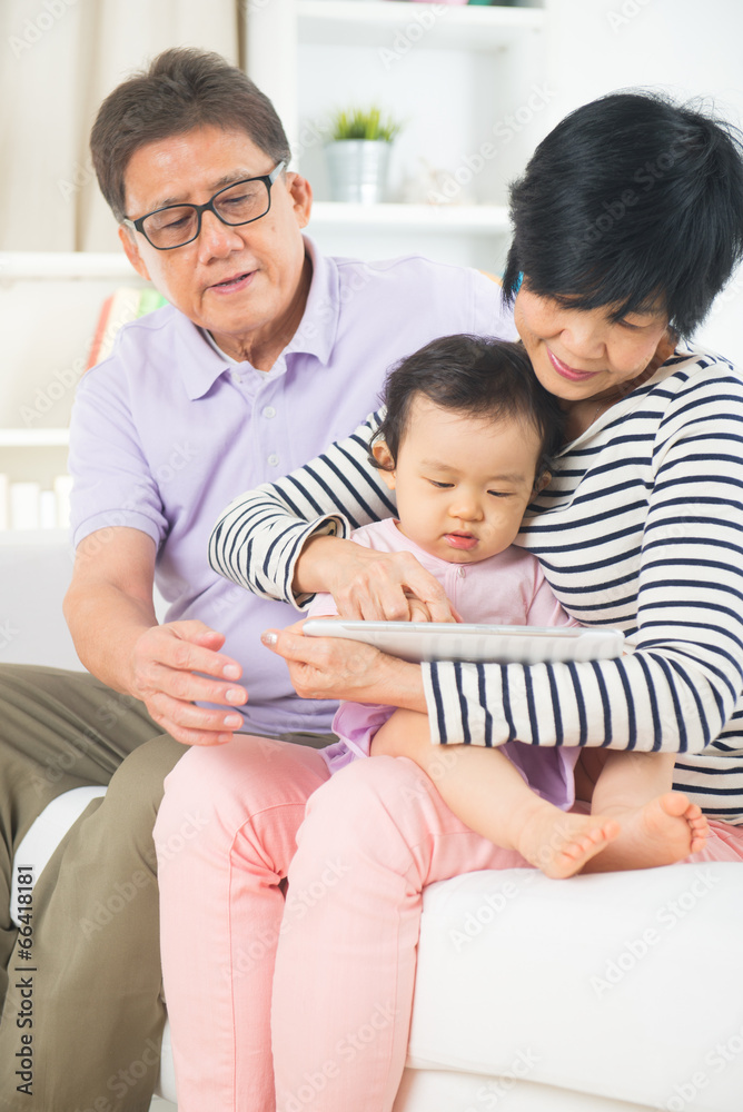 asian grand parents teaching grand son internet with a tablet