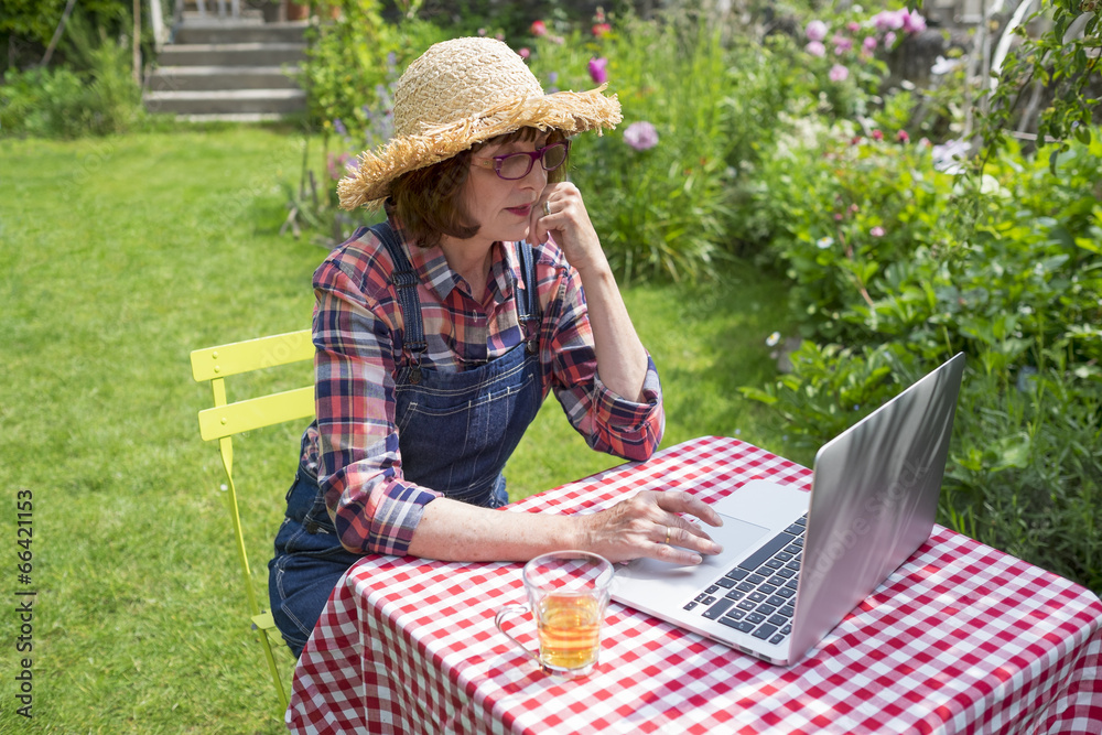 Senior woman using a laptop computer in her garden
