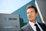 Portrait of businessman standing in front of modern building