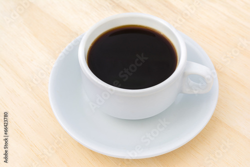 Black coffee in a white cup on wood.