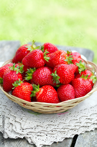 basket with strawberries on a garden wooden table