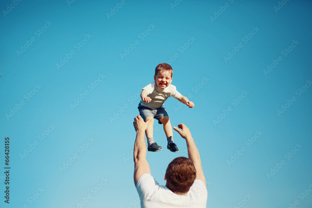 Happy joyful child, father fun throws up son in the air Happy joyful child, father fun throws up son in the air