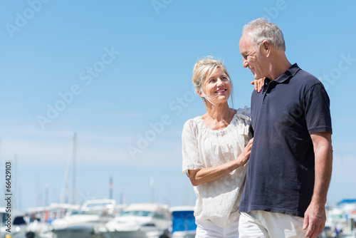 glückliches, älteres paar geht am hafen entlang