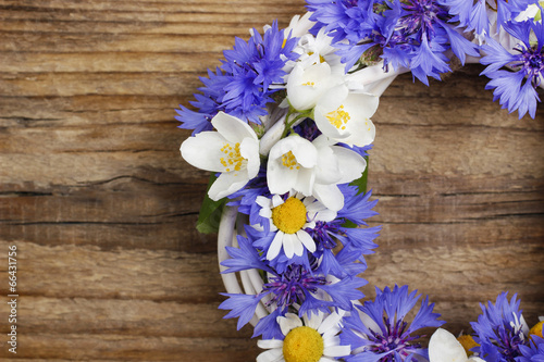 Wicker wreath decorated with cornflowers, chamomiles and jasmine