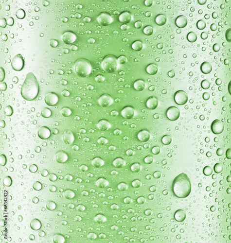 Water drops over green glass background.