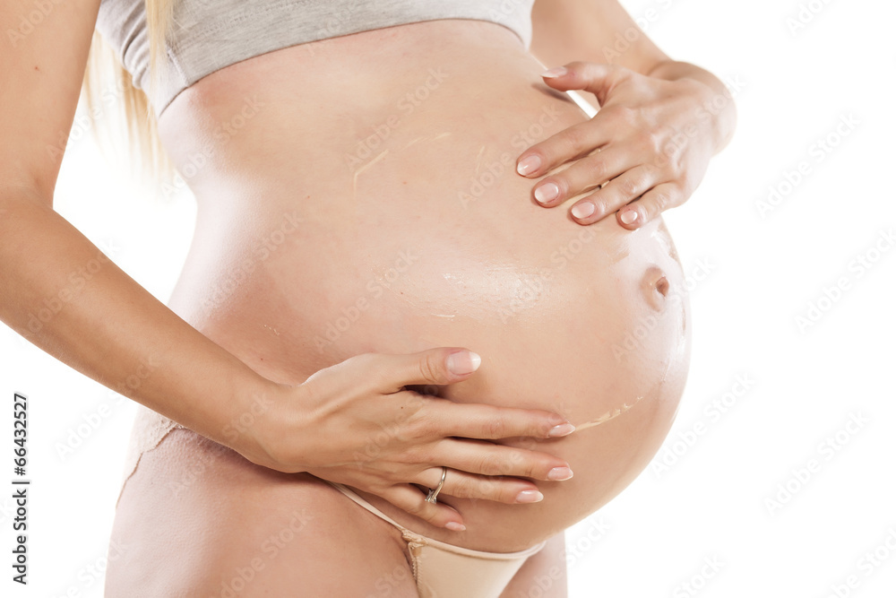 Pregnant women apply cosmetics on her stomach