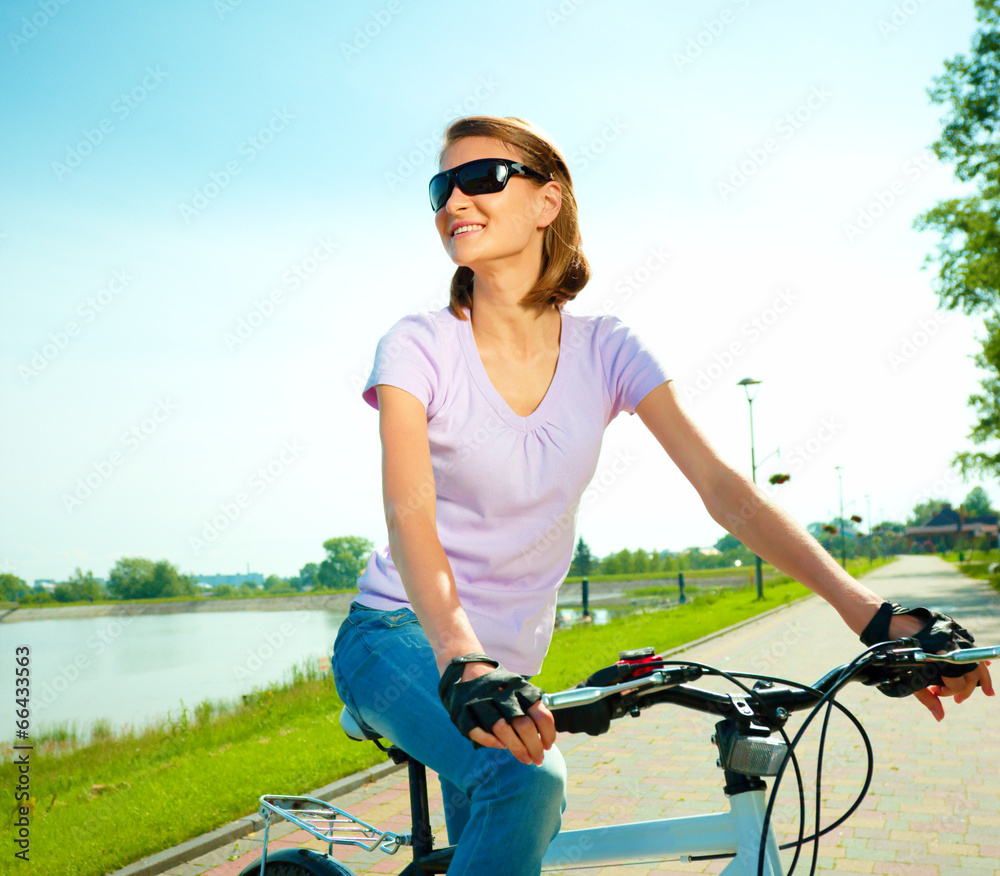 Young woman is sitting on her bicycle Young woman is sitting on her bicycle