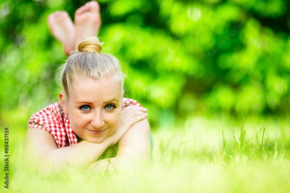 Young attractive woman lying on grass in park. Young attractive woman lying on grass in park.