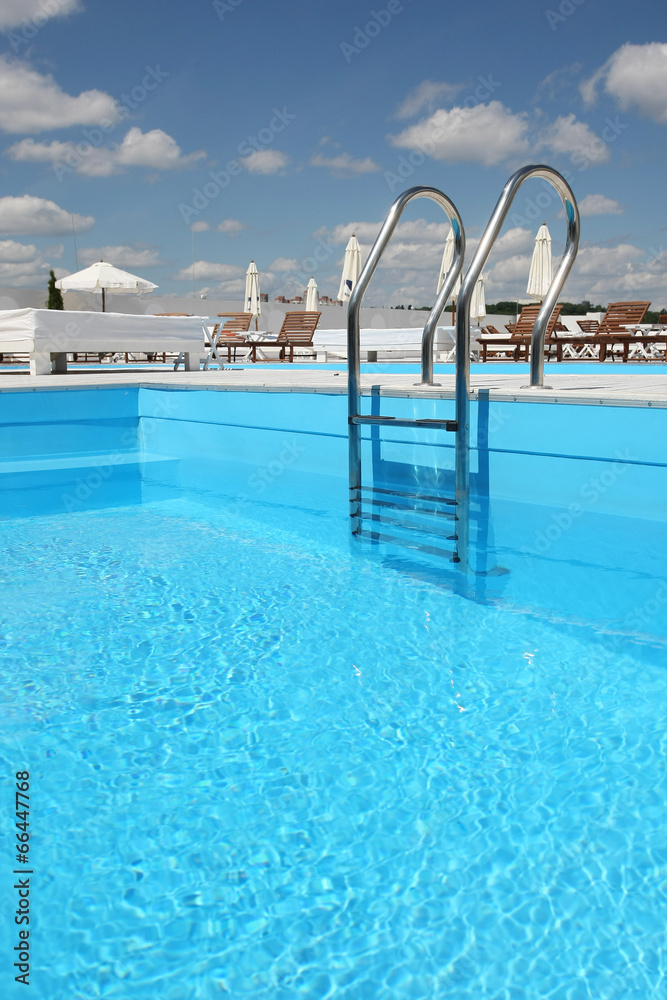 pool with a ladder with beach loungers pool with a ladder with beach loungers