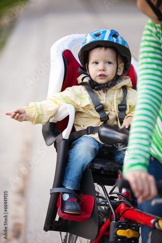 Little boy in the seat bicycle behind mother